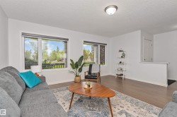 Spacious living area featuring large windows, Vinyl flooring, and white walls - 