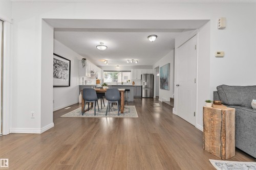 Open concept living space with wood-finish flooring, white walls, recessed lighting, and a white interior door - 4121 Tompkins Way Nw, Edmonton, AB - Indoor
