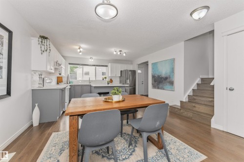 Open concept living space featuring Vinyl plank flooring and a staircase with matching treads - 4121 Tompkins Way Nw, Edmonton, AB - Indoor Photo Showing Dining Room