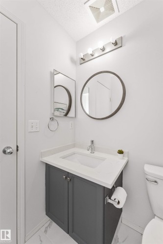 Vanity with gray cabinetry, white quartz countertop, and integrated sink - 4121 Tompkins Way Nw, Edmonton, AB - Indoor Photo Showing Bathroom