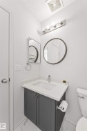 Vanity with gray cabinetry, white quartz countertop, and integrated sink - 