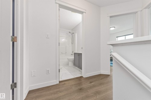 Wood-finish flooring throughout the hallway - 4121 Tompkins Way Nw, Edmonton, AB - Indoor Photo Showing Other Room