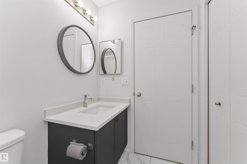 Vanity with light-toned quartz countertop, integrated rectangular sink, and chrome faucet - 4121 Tompkins Way Nw, Edmonton, AB - Indoor Photo Showing Bathroom