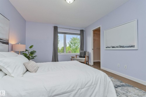 Vinyl plank flooring, and a large window with privacy coverings and a nice view of the tranquil park. - 4121 Tompkins Way Nw, Edmonton, AB - Indoor Photo Showing Bedroom