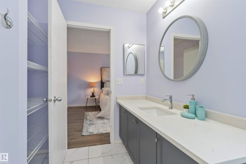 Double vanity with integrated sinks and a light-toned countertop - 4121 Tompkins Way Nw, Edmonton, AB - Indoor Photo Showing Bathroom