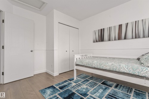 Vinyl plank flooring, white paneled interior doors, and ample closet space. - 4121 Tompkins Way Nw, Edmonton, AB - Indoor Photo Showing Bedroom