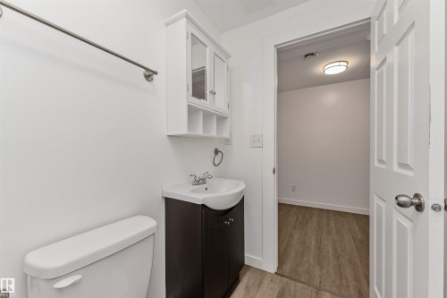 Bathroom featuring a white toilet, dark wood-finish vanity, and a wall-mounted medicine cabinet - 4121 Tompkins Way Nw, Edmonton, AB - Indoor Photo Showing Bathroom