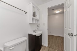 Bathroom featuring a white toilet, dark wood-finish vanity, and a wall-mounted medicine cabinet - 