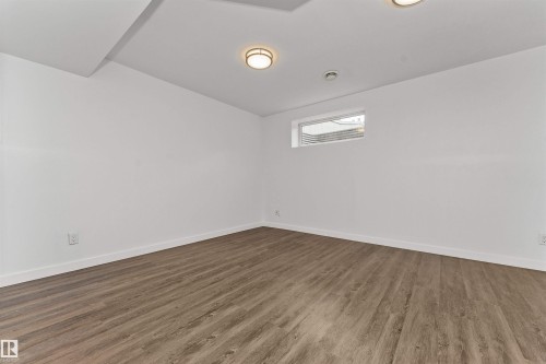 Family room or 5th bedroom with vinyl flooring, white walls, and a large window - 4121 Tompkins Way Nw, Edmonton, AB - Indoor Photo Showing Other Room