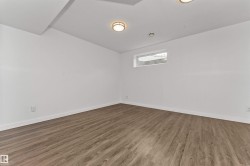 Family room or 5th bedroom with vinyl flooring, white walls, and a large window - 