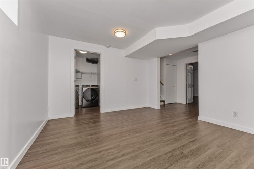 Vinyl plank flooring throughout, bright white walls, recessed laundry area with new appliances. Great family room or 5th bedroom with a large window - 4121 Tompkins Way Nw, Edmonton, AB - Indoor Photo Showing Other Room
