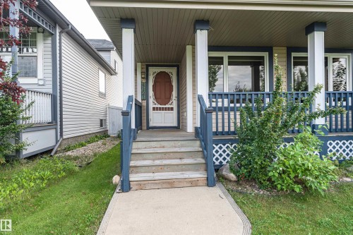 Front porch featuring white columns and dark blue railings - 4121 Tompkins Way Nw, Edmonton, AB - Outdoor With Deck Patio Veranda