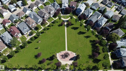 Community featuring a central green space with walking paths, mature trees, and a circular paved area - 4121 Tompkins Way Nw, Edmonton, AB - Other