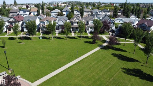 Expansive green space featuring paved pedestrian pathways and mature trees - 4121 Tompkins Way Nw, Edmonton, AB - Outdoor