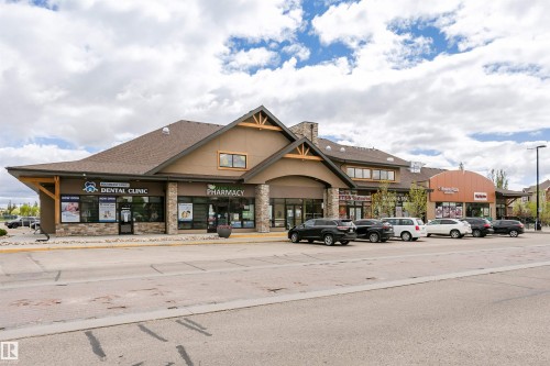 Retail building with stone accents, gable roof lines, and storefront windows - 4121 Tompkins Way Nw, Edmonton, AB - Outdoor