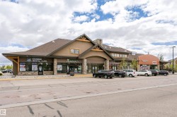 Retail building with stone accents, gable roof lines, and storefront windows - 