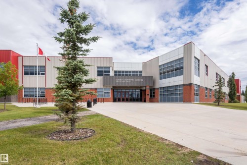 Multi-story commercial building featuring red and cream-colored paneling - 4121 Tompkins Way Nw, Edmonton, AB - Outdoor