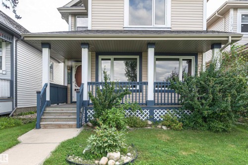 Front exterior with light-toned siding, covered porch, and white trim - 4121 Tompkins Way Nw, Edmonton, AB - Outdoor With Deck Patio Veranda With Facade