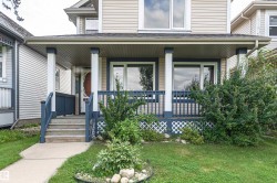 Front exterior with light-toned siding, covered porch, and white trim - 