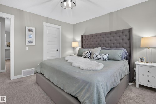 Spacious room featuring neutral wall tones, plush carpeting, a contemporary ceiling fixture, white trim, and a paneled interior door - 17305 73 Street Nw, Edmonton, AB - Indoor Photo Showing Bedroom