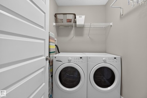 Dedicated laundry area featuring a white front-load washer and dryer, wire shelving, and neutral wall tones - 17305 73 Street Nw, Edmonton, AB - Indoor Photo Showing Laundry Room