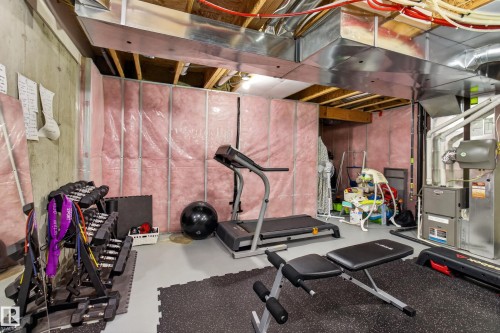 Unfinished basement space featuring visible insulation, concrete walls, exposed ductwork, exposed ceiling joists, and a utility area with mechanical systems - 17305 73 Street Nw, Edmonton, AB - Indoor Photo Showing Gym Room