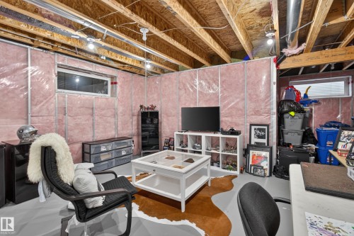 Unfinished basement area featuring exposed ceiling joists, insulation-wrapped walls, and painted concrete flooring - 17305 73 Street Nw, Edmonton, AB - Indoor Photo Showing Basement