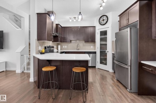 Contemporary kitchen with wood-finish flooring and dark wood cabinetry - 17305 73 Street Nw, Edmonton, AB - Indoor Photo Showing Kitchen With Stainless Steel Kitchen With Upgraded Kitchen