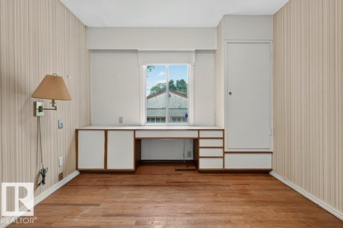 Wood-finish flooring with vertical striped wall covering - 9026 92 Street Nw, Edmonton, AB - Indoor