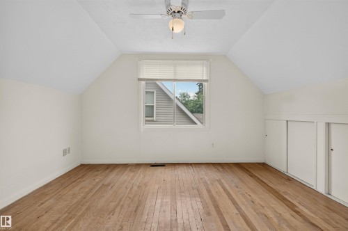 Sloped ceilings, wood-finish flooring, a ceiling fan, a window, and built-in storage - 9026 92 Street Nw, Edmonton, AB - Indoor Photo Showing Other Room