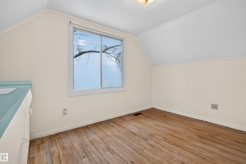 Hardwood flooring, painted walls, window with natural lighting, textured ceiling, built-in cabinetry with a blue counter - 9026 92 Street Nw, Edmonton, AB - Indoor Photo Showing Other Room