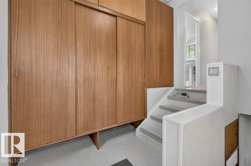 Built-in wood-finish cabinetry, light-toned flooring, and a multi-level staircase - 9026 92 Street Nw, Edmonton, AB - Indoor