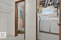 Laundry area featuring a window and exposed ceiling utilities - 