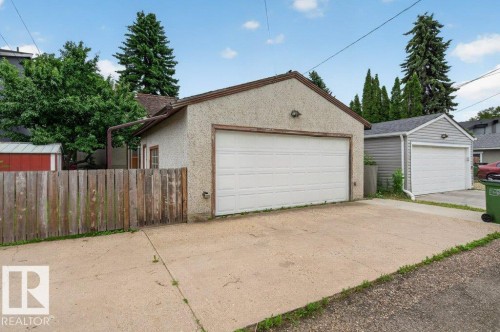 Detached garage with a white overhead door, stucco exterior, and concrete driveway - 9026 92 Street Nw, Edmonton, AB - Outdoor With Exterior