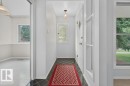Entryway featuring diamond-patterned floor tiles, a window with obscure glass, and a paneled entry door with a diamond-shaped glass insert - 9026 92 Street Nw, Edmonton, AB  - Indoor Photo Showing Other Room 