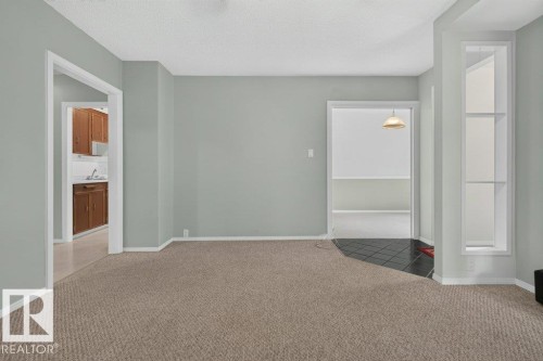 Wall-to-wall carpeting in a neutral tone, white trim, and a built-in shelving unit - 9026 92 Street Nw, Edmonton, AB - Indoor Photo Showing Other Room
