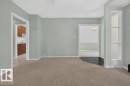 Wall-to-wall carpeting in a neutral tone, white trim, and a built-in shelving unit - 9026 92 Street Nw, Edmonton, AB  - Indoor Photo Showing Other Room 