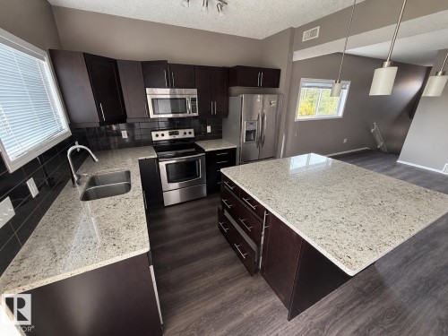Photos digitally enhanced - #21 6520 2 Av Sw, Edmonton, AB - Indoor Photo Showing Kitchen With Double Sink With Upgraded Kitchen