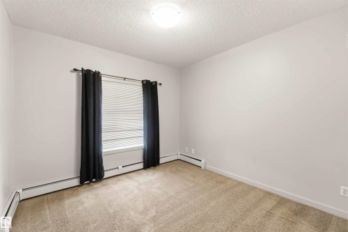 Neutral wall color with textured ceiling - #414 5510 Schonsee Dr Nw, Edmonton, AB - Indoor Photo Showing Other Room