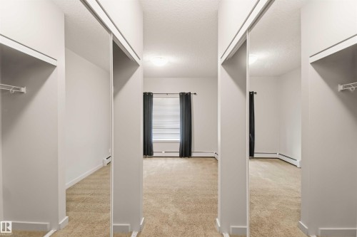 Wall-to-wall carpeting with mirrored closet doors - #414 5510 Schonsee Dr Nw, Edmonton, AB - Indoor