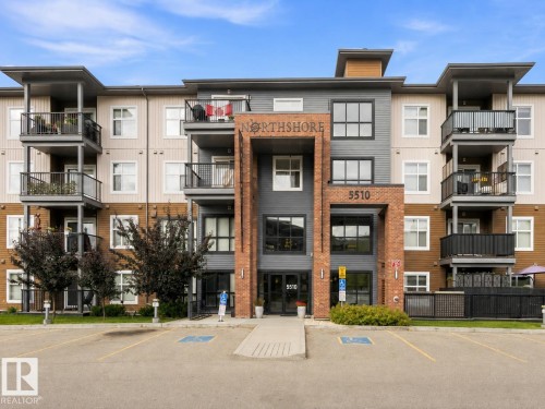 Multi-level building with brick and siding facade, private balconies, and an onsite parking area - #414 5510 Schonsee Dr Nw, Edmonton, AB - Outdoor With Facade