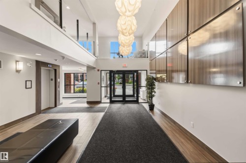 Two-story foyer featuring wood-finish flooring and a central lighting fixture - #414 5510 Schonsee Dr Nw, Edmonton, AB - Indoor Photo Showing Other Room