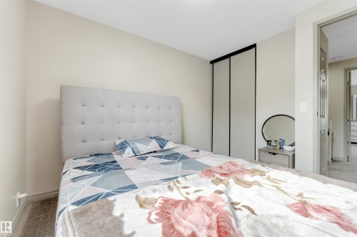 Neutral-toned walls with carpet flooring, a closet with sliding panel doors, and a door frame - #37 1411 Mill Woods Rd E Nw, Edmonton, AB - Indoor Photo Showing Bedroom