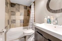 White drop-in bathtub with a mixed-tone tiled surround - 