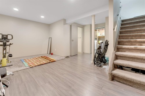 Recessed lighting, wood-finish flooring, carpeted stairs with handrail, and neutral wall paint - #37 1411 Mill Woods Rd E Nw, Edmonton, AB - Indoor
