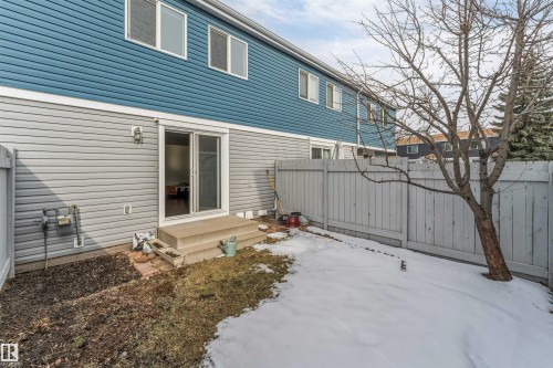 Rear exterior featuring dual-tone siding, privacy fencing, and a patio with sliding glass doors - #37 1411 Mill Woods Rd E Nw, Edmonton, AB - Outdoor With Exterior