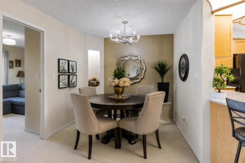 Virtually staged with Dining Table - #233 279 Suder Greens Dr Nw, Edmonton, AB - Indoor Photo Showing Dining Room