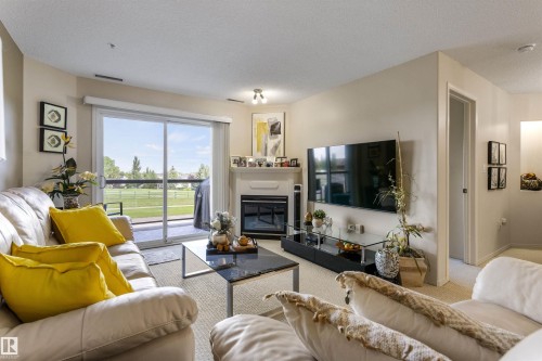 #233 279 Suder Greens Dr Nw, Edmonton, AB - Indoor Photo Showing Living Room With Fireplace