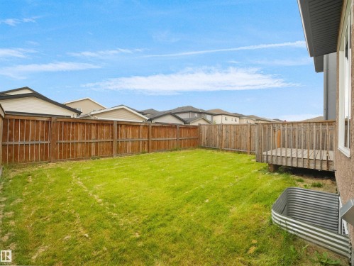 Expansive green lawn with a wood privacy fence and a dedicated wood deck area - 17020 62 Street Nw, Edmonton, AB - Outdoor