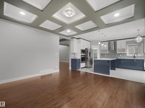 Hardwood-finish flooring extending into the kitchen with a coffered ceiling and recessed lighting - 17020 62 Street Nw, Edmonton, AB - Indoor
